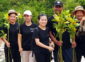 The Sarojin staff standing holding tress they are about to plant